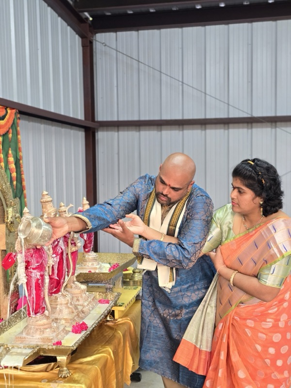 Devotee performing abhishekam at temple