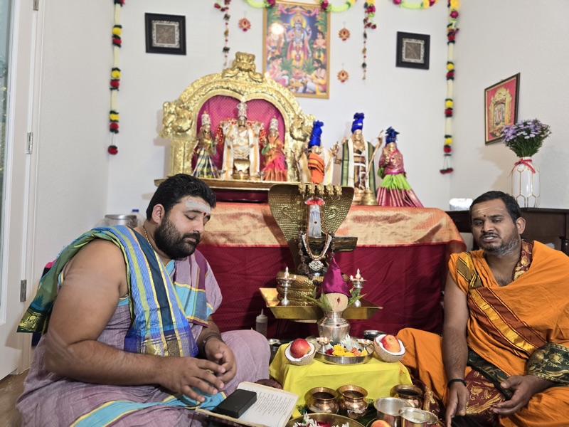 Both priests seated with deity idols