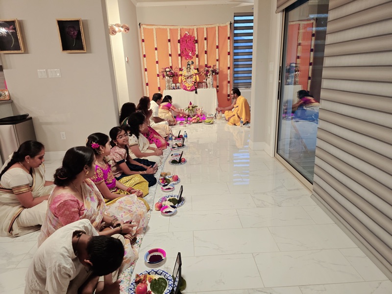 Home pooja with family and Ganesh backdrop