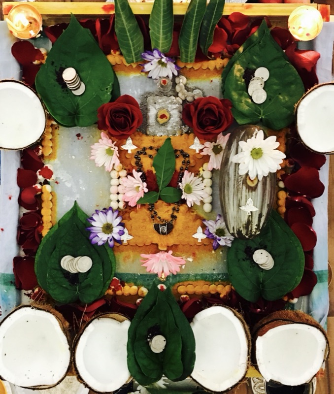 Shiva Lingam with flowers and coconuts